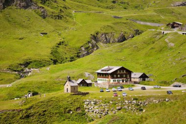 Birkaç küçük evler ve otel binalar. Arabalar binalar Park. Dağ yolu, Grossglockner Hochalpenstrasse, Avusturya eğri çok güzel. Yaz günü.