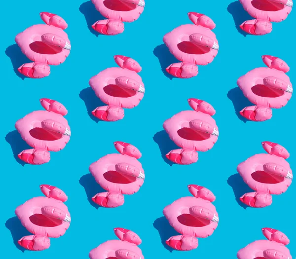 Patrón inconsútil de juguetes inflables de flamenco rosa con una sombra sobre un fondo azul azulado. Un collage de fotos planas. Concepto de verano para textiles, envolturas, papel pintado — Foto de Stock