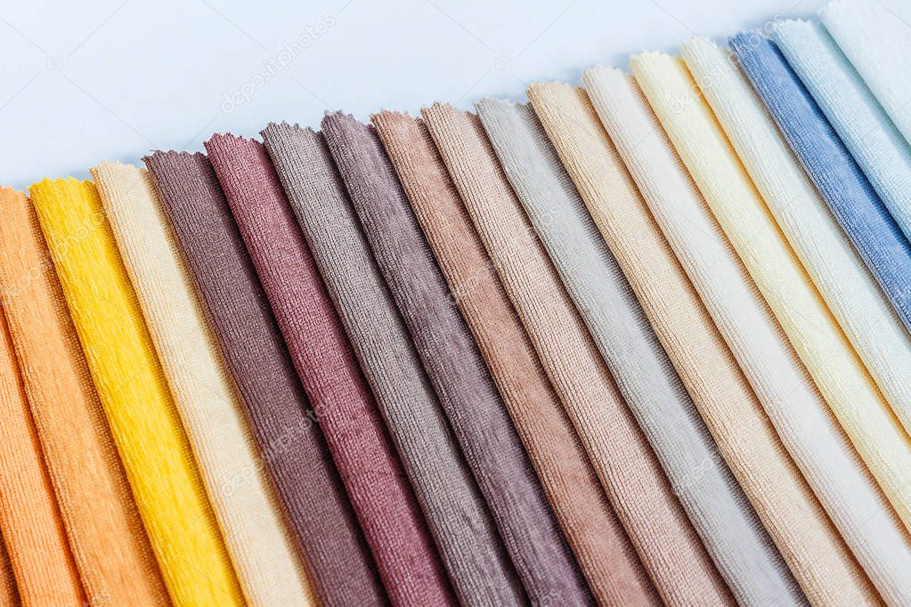 Colorful fabric samples on wooden table and light blurred background