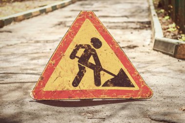 Bir yolda uyarı levhasında çalışır