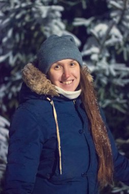 Genç kız gece karlı kış ormanda gülümseyen