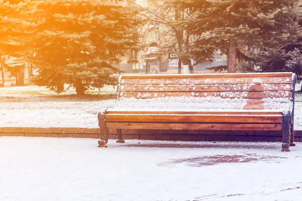 Bänk i en snötäckt park — Stockfoto