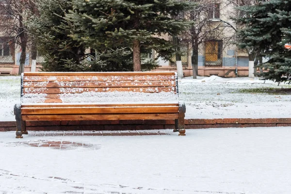 Bänk i en snötäckt park — Stockfoto