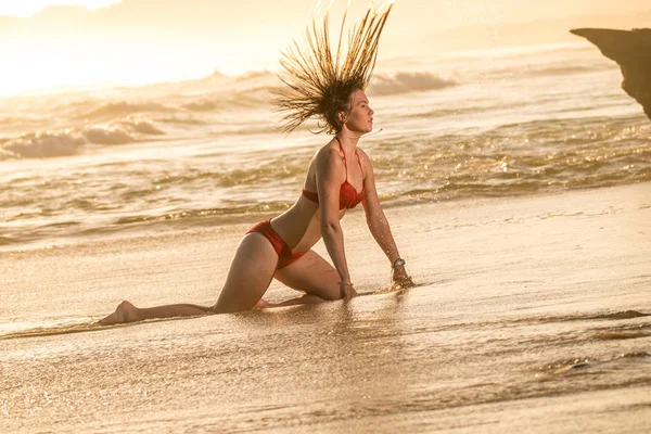 一个迷人的金发女郎在海滩上翻回她的头发 — 图库照片