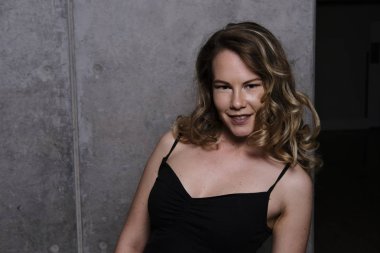 Siyah top yaslanmış ve omuzlarını gösterilen bir muhteşem sarışın manken