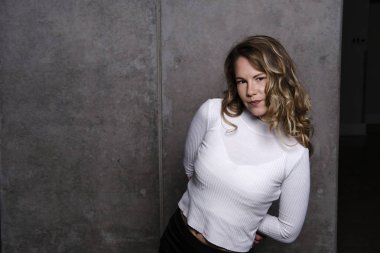 Muhteşem sarışın stüdyo poz içinde beyaz bir elbise içinde