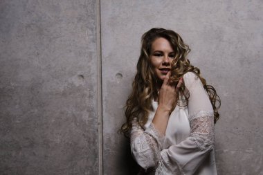 Muhteşem sarışın stüdyo poz içinde beyaz bir elbise içinde