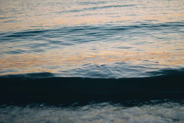 Havsvitt skum på vågkrönet. Bubblande vatten. Vågen går iland. Havsvågor i gryningen. — Stockfoto