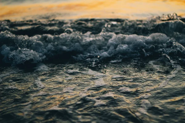 波の紋章に海の白い泡。泡立つ水。波は上陸する。夜明けの海の波. — ストック写真