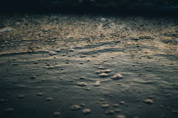 Havsvitt skum på vågkrönet. Bubblande vatten. Vågen går iland. Havsvågor i gryningen. — Stockfoto