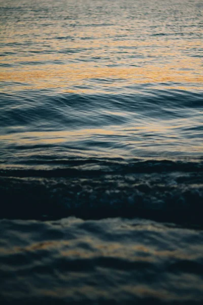 Espuma blanca marina en la cresta de una ola. Agua burbujeante. La ola desembarca. Ondas marinas al amanecer . — Foto de Stock