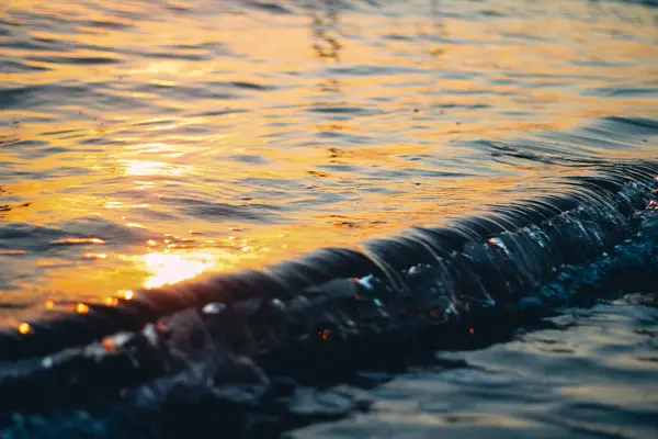 波の紋章に海の白い泡。泡立つ水。波は上陸する。夜明けの海の波. — ストック写真