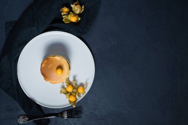 Amerikan gözleme physalis, siyah arka plan ile çilek şurubu dökülür