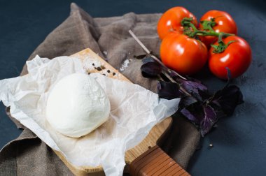 İtalyan mozzarella peyniri, domates, fesleğen. Caprese salatası için malzemeler. Yan görünüm, koyu arka plan
