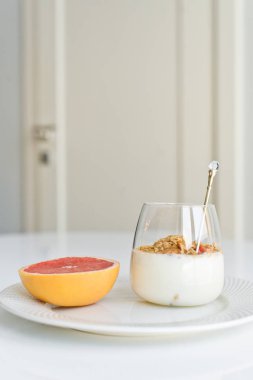 Sağlıklı kahvaltı. Malzemeler: greyfurt, granola. Yan bakış, beyaz arka plan.