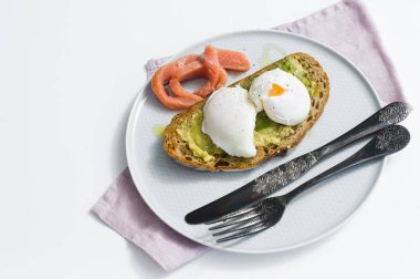 Avokado, yumurta, somon ve siyah ekmek ile kadeh kaldırıyorum. Yan bakış, beyaz arka plan, metin için yer