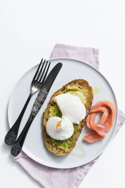 Avokado, yumurta, somon ve siyah ekmek ile kadeh kaldırıyorum. Üstten görünüm, beyaz arka plan
