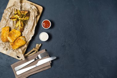 Ahşap Doğrama tahtası üzerinde İngilizce geleneksel balık ve cips. Koyu arka plan, üstten görünüm, metin için yer