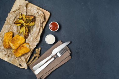 Ahşap Doğrama tahtası üzerinde İngilizce geleneksel balık ve cips. Koyu arka plan, üstten görünüm, metin için yer