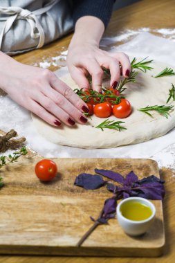 Şef, elmalı hazırlar domates hamur bırakır. yan görünüm, ahşap arka plan