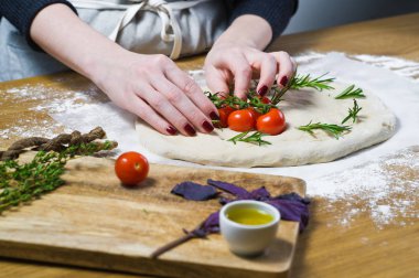 Şef, elmalı hazırlar domates hamur bırakır. yan görünüm, ahşap arka plan