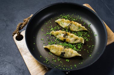 Bir tavada kızarmış Kore köfte. Koyu arka plan, üstten görünüm