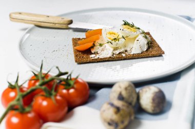 Tost bıldırcın yumurtası. Malzemeler domates, yumurta, peynir, çavdar ekmeği. Beyaz arka plan, yan görünüm