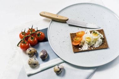 Tost bıldırcın yumurtası. Malzemeler domates, yumurta, peynir, çavdar ekmeği. Beyaz arka plan, yan görünüm