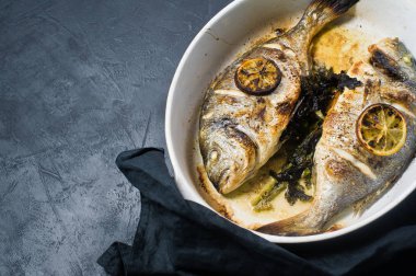 Dorado bir dilim limon ile balık pişmiş. Koyu arka plan, üstten görünüm, metin için yer