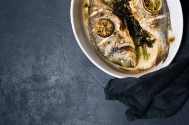 Dorado bir dilim limon ile balık pişmiş. Koyu arka plan, üstten görünüm, metin için yer