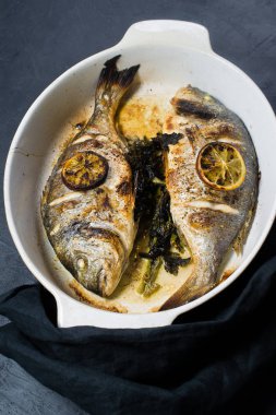 Bir dilim limon ile ızgara Dorado balık. Koyu arka plan, üstten görünüm