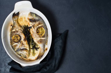 Dorado bir dilim limon ile balık pişmiş. Koyu arka plan, üstten görünüm, metin için yer