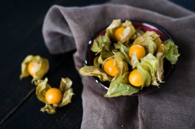 Çilek physalis siyah kase, koyu kumaş, koyu arka plan, üstten görünüm, seçici odak
