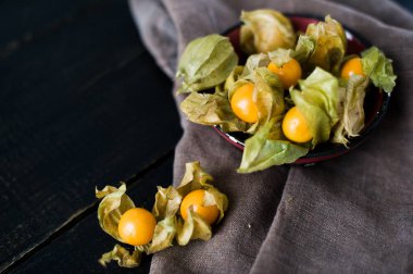 Çilek physalis bir siyah kase, koyu arka plan, üstten görünüm