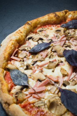 İtalyan pizza jambon, mantar ve fesleğen. Koyu arka plan, üstten görünüm, görünümü kapatın