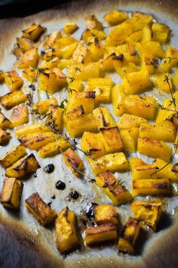 Bir fırın tepsisine fırın balkabağı. Koyu arka plan, üstten görünüm