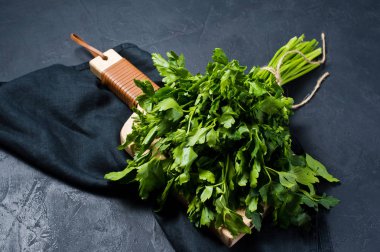 maydanoz bir Ahşap doğrama tahtası üzerinde. Koyu arka plan, yan görünüm