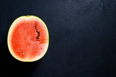 Yarım bir karpuz. Koyu arka plan, üstten görünüm