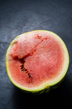 Yarım bir karpuz. Koyu arka plan, üstten görünüm