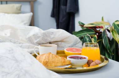 Fransız kahvaltı otelde. Kahve, reçel, kruvasan, portakal suyu, greyfurt, lychee. Yan görünüm, açık renkli