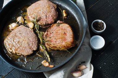 Pişirme pan bir kızartma biftek, biftek. Üstten Görünüm, siyah arka plan