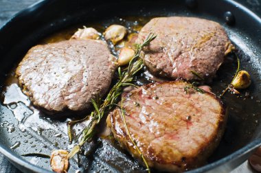 Üç fileto biftek tavada pişirme. Üstten Görünüm, siyah arka plan, kapat