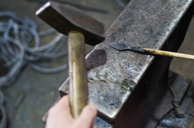 Demirci bir ok ucu çekiç örs üzerinde uydurandan