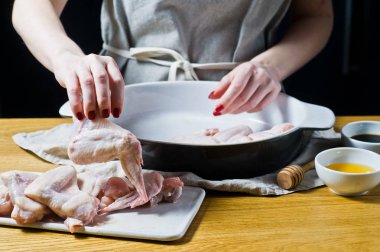 Şef tavuk kanat ızgara hazırlar. Yan görünüm