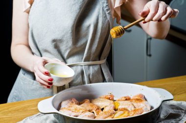 Şef'in eller çiğ tavuk kanadı bal yemek. Yan görünüm
