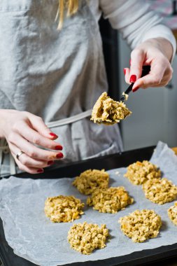 Şef Aşçı hazırlanıyor, tepsiler hamur yayılır. Yan görünüm, siyah arka plan, mutfak.