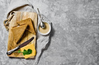 Peynir dönüş, siyah ekmek, hindi eti ve roka ile tost. Gri arka plan, üstten görünüm, metin için yer