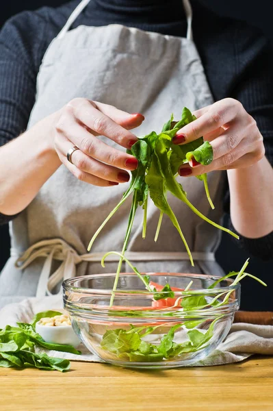 Chef Feminino Prepara Salada Com Folhas Arugula Fundo Preto Vista — Fotografia de Stock
