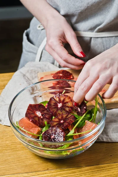 Chef Pone Rebanadas Naranja Roja Tazón Ensalada Cocinando Fondo Negro — Foto de Stock