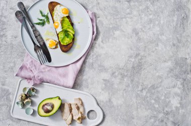 Siyah ekmek tost yumurta ile Avacado sandviç. Gri arka plan, üstten görünüm, metin için yer